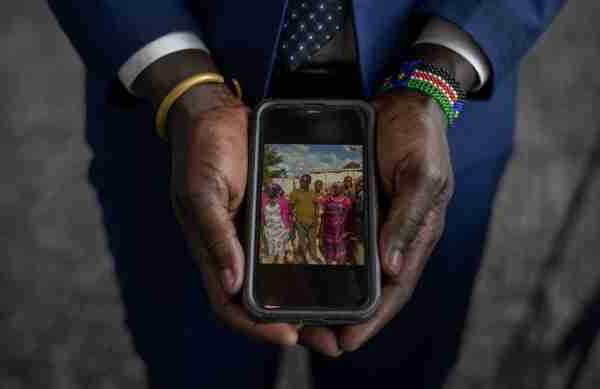 A person's hands holds a phone showing a picture of people